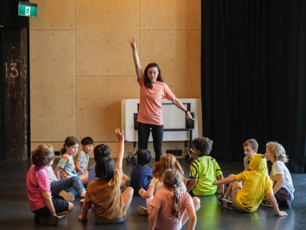 Children sitting around with a teacher at a holiday workshop